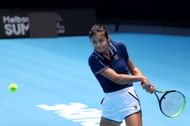 Emma Raducanu of Great Britain plays a backhand during a practice session at Melbourne Park